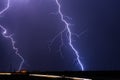 Lightning bolts strike an electrical power line during a storm Royalty Free Stock Photo