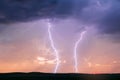 Lightning bolts strike in a thunderstorm at sunset Royalty Free Stock Photo