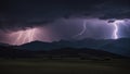 lightning in the mountains A spectacular lightning storm illuminates the dark and cloudy sky over a silhouetted mountain range. Royalty Free Stock Photo