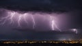 lightning over the city A city glows with life as a lightning storm flashes in the purple sky Royalty Free Stock Photo