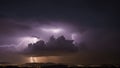 lightning over the city This is a photo of a lightning storm over a city at night with a purple sky and dark clouds. Royalty Free Stock Photo