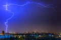 Lightning over the city at the summer storm. Dramatic, breathtaking atmospheric natural phenomenon. Royalty Free Stock Photo