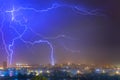 Lightning over the city at the summer storm. Dramatic, breathtaking atmospheric natural phenomenon. Royalty Free Stock Photo