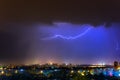 Lightning over the city at the summer storm. Dramatic, breathtaking atmospheric natural phenomenon. Royalty Free Stock Photo