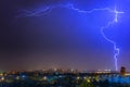 Lightning over the city at the summer storm. Dramatic, breathtaking atmospheric natural phenomenon. Royalty Free Stock Photo