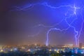 Lightning over the city at the summer storm. Dramatic, breathtaking atmospheric natural phenomenon. Royalty Free Stock Photo
