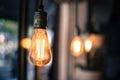 Lightning in the restaurant: Close up of a hanging, orange lightbulb Royalty Free Stock Photo