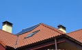 Lightning rod on rooftop. House roof lightning protection systems with attic skylight and solar water heater Royalty Free Stock Photo