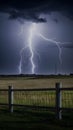 Lightning storm illuminates field with foreground fence, dramatic scene Royalty Free Stock Photo