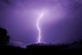 A very branching lightning flashes above the roofs of city houses in a summer thunderstorm. Royalty Free Stock Photo