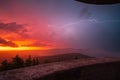 Lightning streaks across the sky during a thunderstorm in the Black Forest while the morning sun turns the sky red