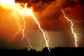 Lightning strike on the dark cloudy sky. Orange, yellow and red toned image Royalty Free Stock Photo