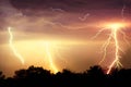 Lightning strike on the dark cloudy sky. Orange, yellow and red toned image Royalty Free Stock Photo