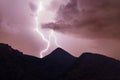 Lightning strike on the night red cloudy sky in the mountains Royalty Free Stock Photo