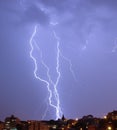 Lightning strike over dark blue sky in night city Royalty Free Stock Photo