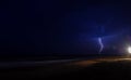 Lightning strike over the sea in night. Dark beach background Royalty Free Stock Photo