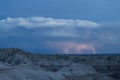 Lightning strikes the horizon over an eerie landscape in the Badlands National Park. Royalty Free Stock Photo