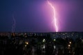 Lightning strikes down over the city at night. Royalty Free Stock Photo