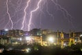Lightning strikes over the city buildings