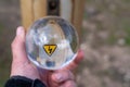 The lightning symbol lightning on a yellow triangular background is visible through a glass ball held in his hand