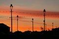 Lights and buildings against red sky after sunset.