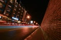 Lights from cars at Tha Pae Gate in the night with many Tuk Tuk parked alongside the road, at Chiang Mai.