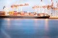 Lights, cranes and container ships at Port of Tauranga at dawn