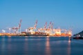 Lights, cranes and container ships at Port of Tauranga at dawn