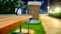 The lights that illuminate between orange benches sit on the side of the garden path at night. Royalty Free Stock Photo