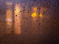 The lights of the night city during the rain behind a glass covered with drops of water. Abstract blurred background Royalty Free Stock Photo