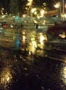 The lights of the night city through the wet glass. Abstract view.