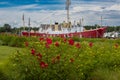 The Lightship Overfalls moored in the harbor at Lewes, Delaware with hibiscus flowers in the foreground . Royalty Free Stock Photo