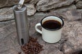 Lightweight coffee grinder for camping and the outdoor life with enamal coffee cup and beans Royalty Free Stock Photo