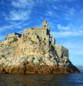 Liguria: the Saint Peter church of Portovenere on the cliff rockview and blue sky with clouds from the boat in the afternoon Royalty Free Stock Photo