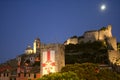 View of Portovenere`s buildings at night under the moon with a castle, tower and cathedral illuminated Royalty Free Stock Photo