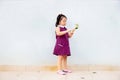 Liitle asian girl standing alone and holding a small plant in the hand