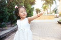 Liitle asian girl standing and poiting finger to the right. Future children concept