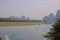 Lijiang River between Guilin and Yangshuo, China with boats cruising down the river with the misty karst mountains Royalty Free Stock Photo