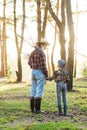 Likable confident bearded grandpa in forest going fishing together with his 10-aged grandson and talking about fishing.