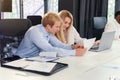 Likable purposeful business partners carefully studying financial documents with charts at the boardroom table at the Royalty Free Stock Photo