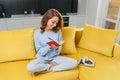 Likable young woman writing her personal notes into her diary while sitting in the modern stylish kitchen.