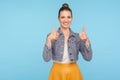Like, this is awesome! Portrait of lovely fashionably dressed woman with hair bun and perfect teeth smile showing thumbs up