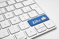 Like blue button with a thumb up icon on a white isolated keyboard - social media concept Royalty Free Stock Photo