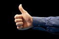 Like. Closeup image of human hand with thumb up on black background Royalty Free Stock Photo