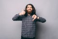 Like or dislike, Photo of young man with beard and long hair showing agree or disagree gesture