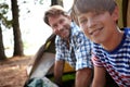 Like father like son. Portrait of a father and son on a camping trip in the woods. Royalty Free Stock Photo