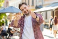 Happy man showing thumbs up, like sign positive something good positive feedback in city street