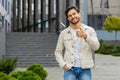 Happy Indian man show thumbs up like sign positive something good positive feedback in city street