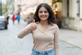 Happy woman showing thumbs up, like sign positive something good positive feedback in city street Royalty Free Stock Photo