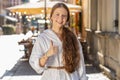 Happy girl showing thumbs up, like sign positive something good positive feedback in city street Royalty Free Stock Photo